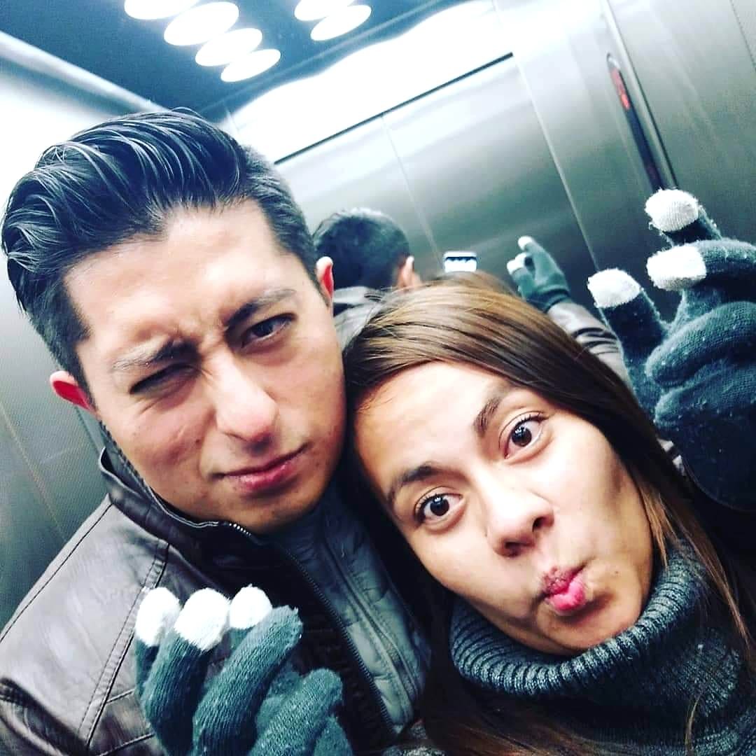 Two team members pulling faces in an elevator.