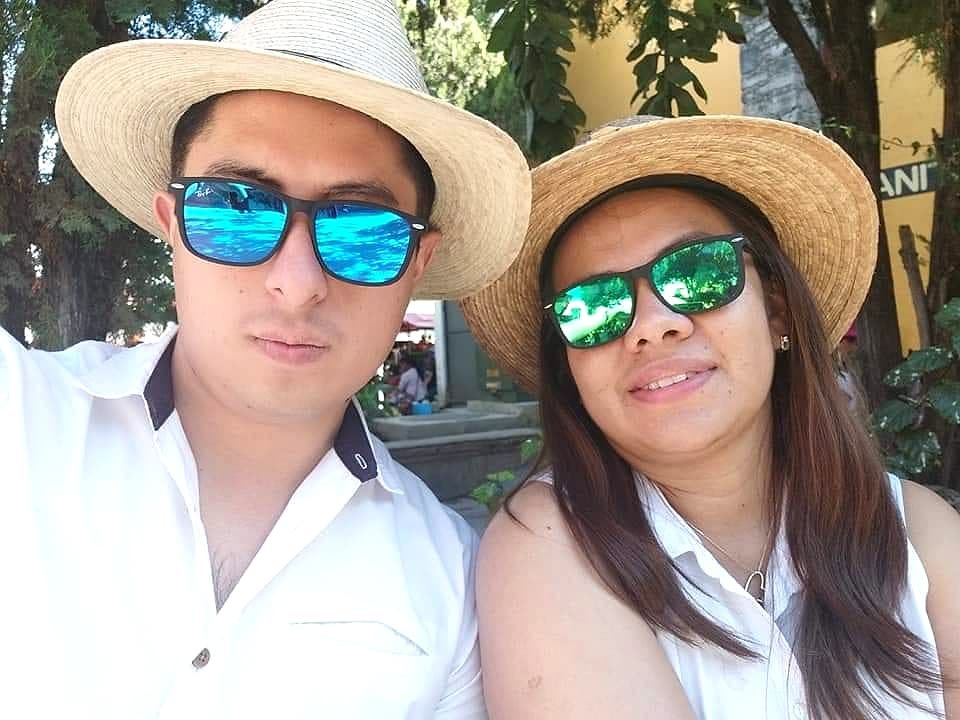 Two team members in hats and sunglasses on a trip.